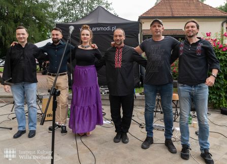 fotografia. dni wyszehradzkie w willi decjusza. członkowie zespołu balkan artz pozują do zdjęcia. sześć osób stoi w rzędzie na kamiennym tarasie willi decjusza.